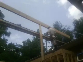 Carpenter setting a ridge beam over a new addition frame — Ice Dam Removal by Roofing Brothers in Pfafftown