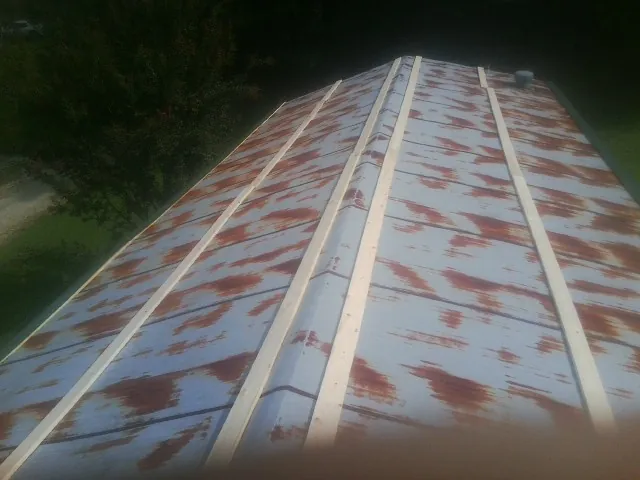 Rusted metal roof panels with new wood purlins before replacement — Storm Damage Roof Repair in Pfafftown by Roofing Brothers