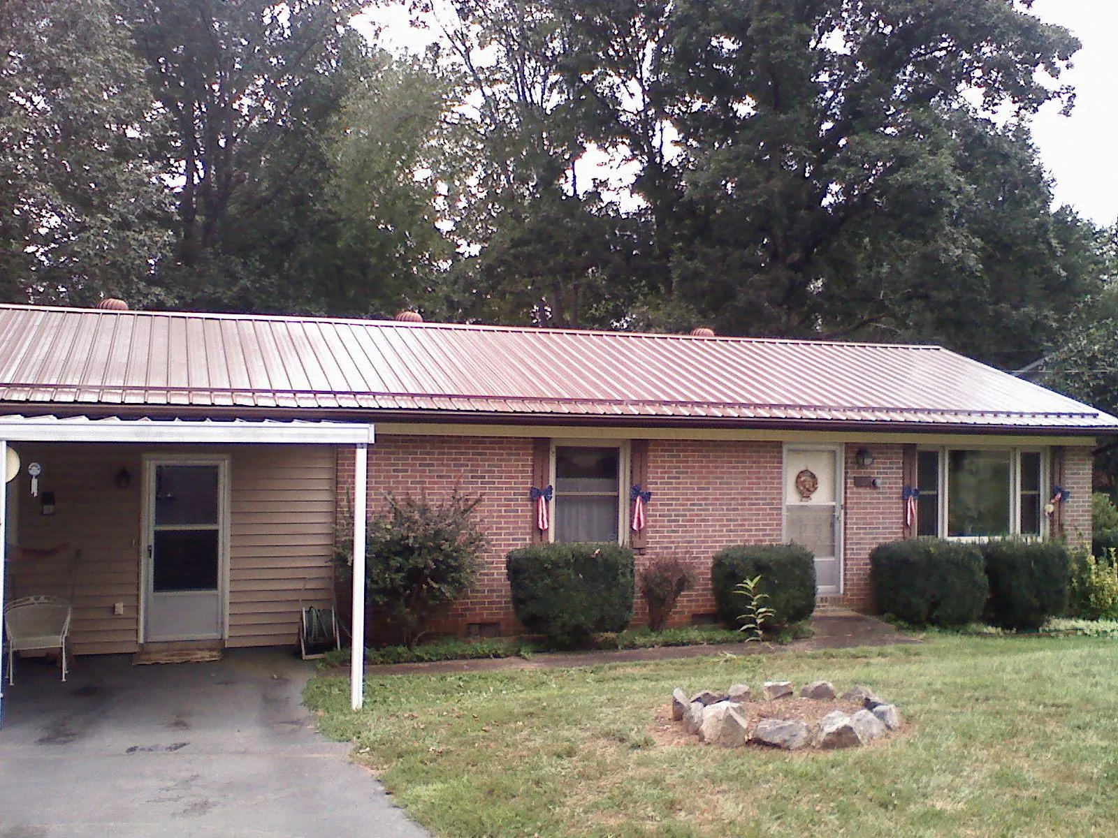 Bronze metal roof and carport on a brick ranch home — Roof Repair work by our crew in Pfafftown
