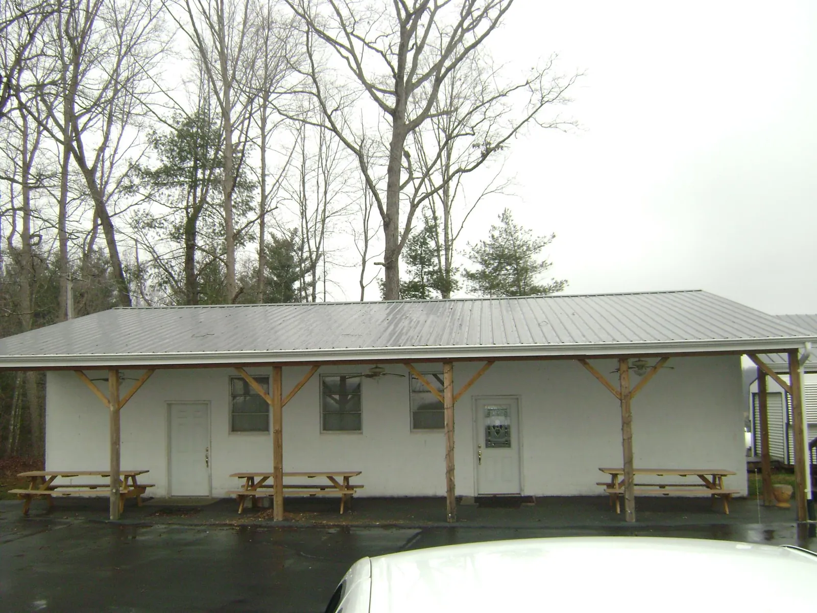 Gray metal roof over a block building with a timber post porch in Pfafftown