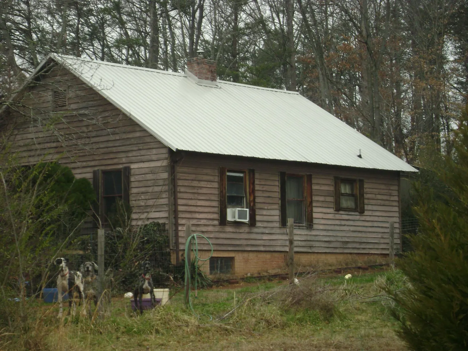 White metal roof on an old wood sided farmhouse, from a Metal Roof Installation job in Pfafftown